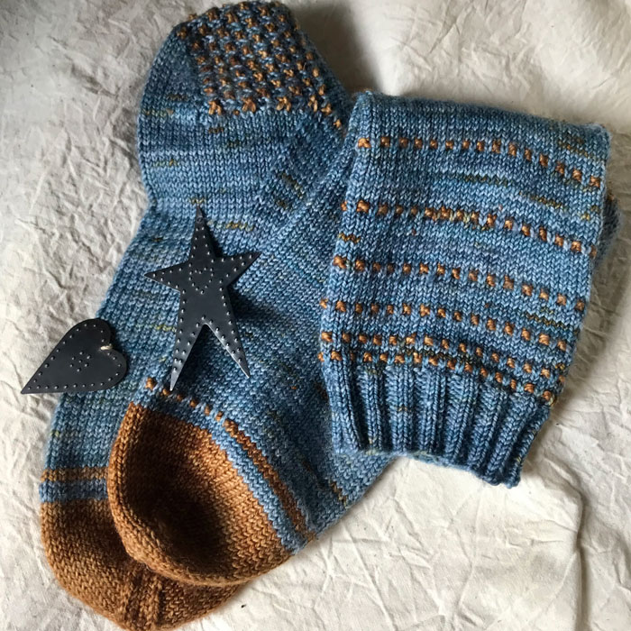 A pair of blue socks with ginger toes, heels and stripe pattern