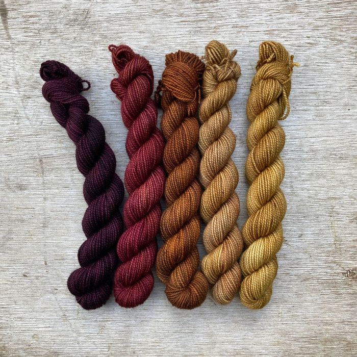 Five mini skeins ranging in colour from dark purple to gold