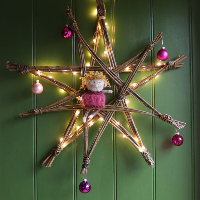 A fairy balanced on a decorated willow star