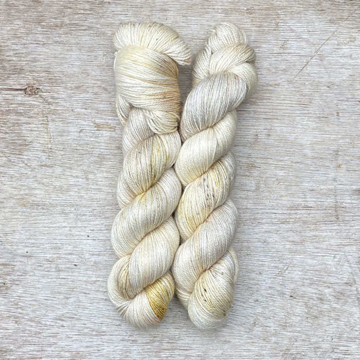 Two skeins of cream splashed with gold and coffee