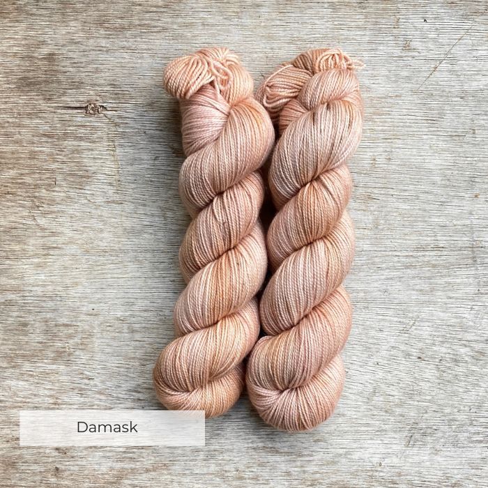 Three skeins of yarn the colour of whitewashed terracotta