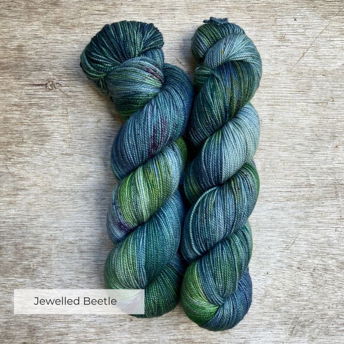 Three skeins of yarn in light blue, emerald and ink