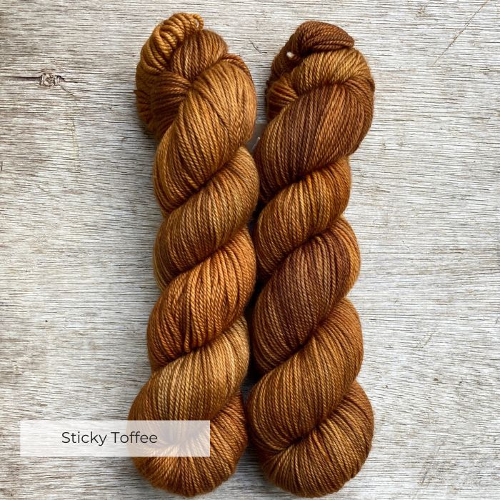 Two skeins of plump DK in shades of amber, gold and toffee