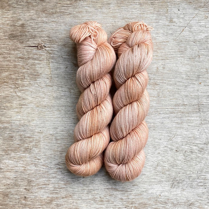 Two skeins of yarn the colour of whitewashed terracotta