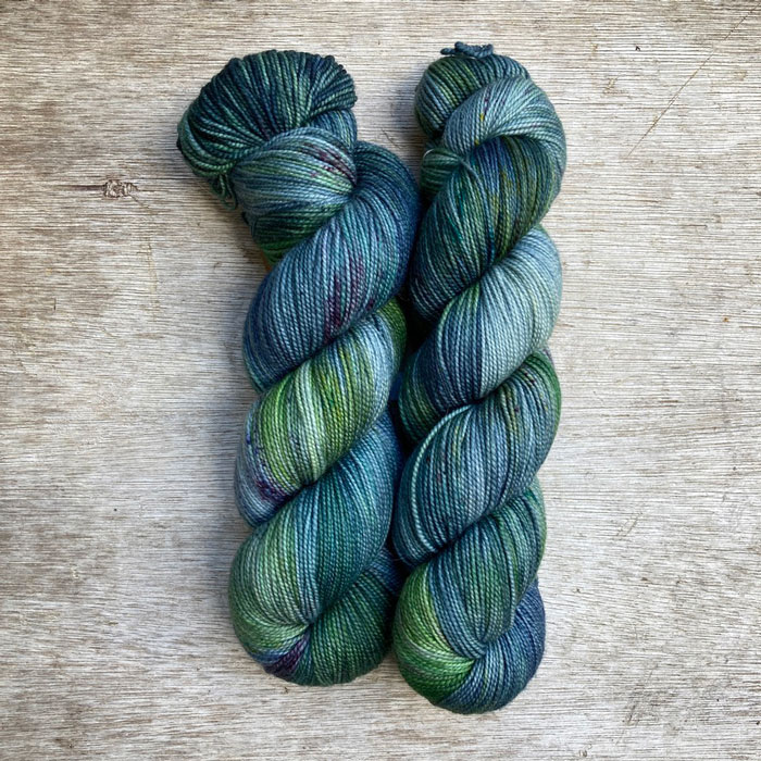 Two skeins of yarn in light blue, emerald and ink