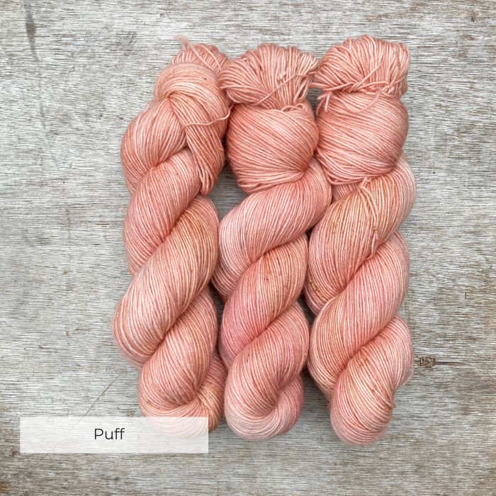 Three skeins of pink yarn with faint yellow speckles