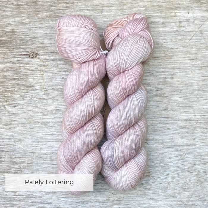 Two skeins of wool in pale pink, buff, grey and lilac