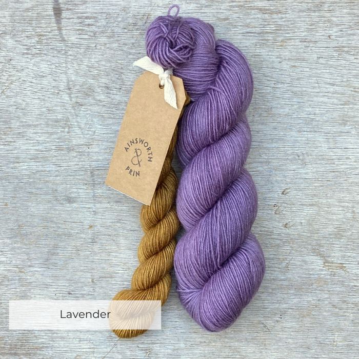 A full skein of Merino& Mohair sock yarn in a lavender colour with a mini in mustard
