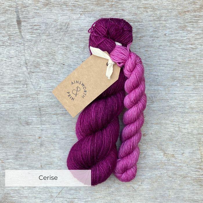A full skein of Merino& Mohair sock yarn in a deep cerise colour with a mini in pink