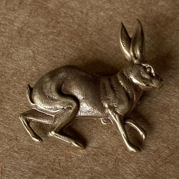 A pressed metal brooch in the shape a hare