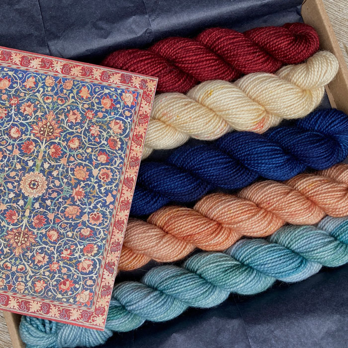 Five mini skeins in a box with a postcard that inspired the colours