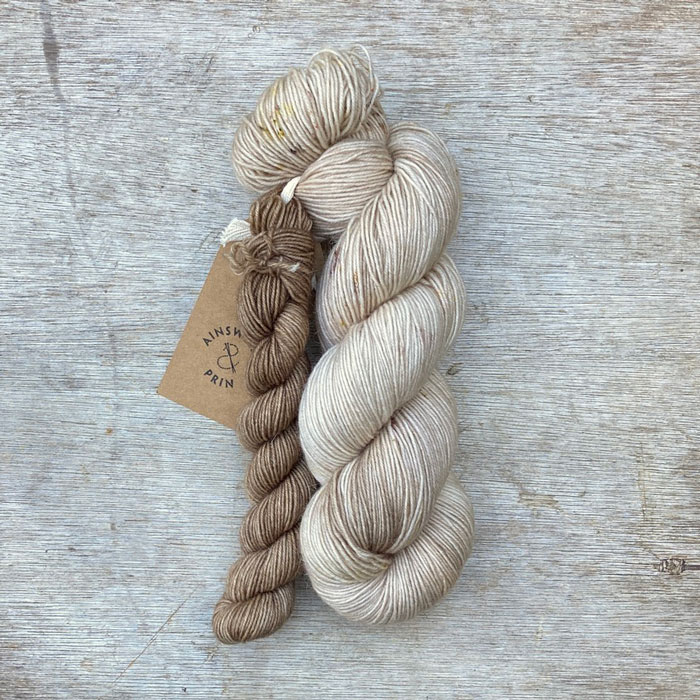 A full skein of Merino& Mohair sock yarn in a lightly speckled natural colour with a mini in a deeper buff