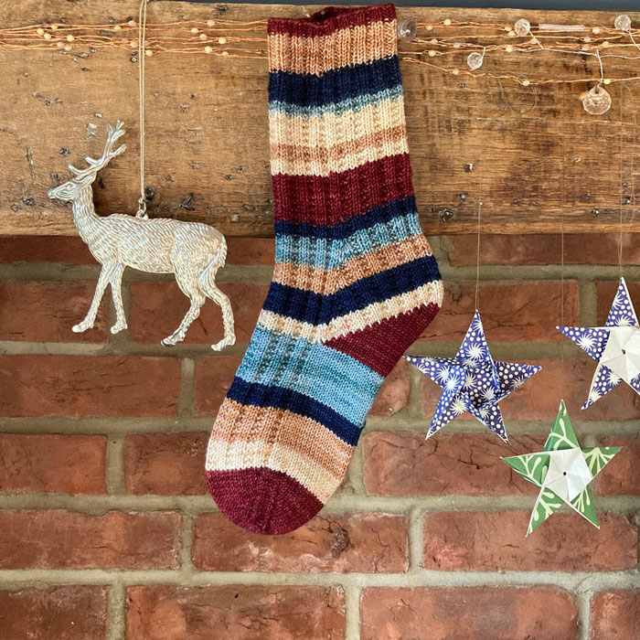 A stripy sock hanging from a wooden beam