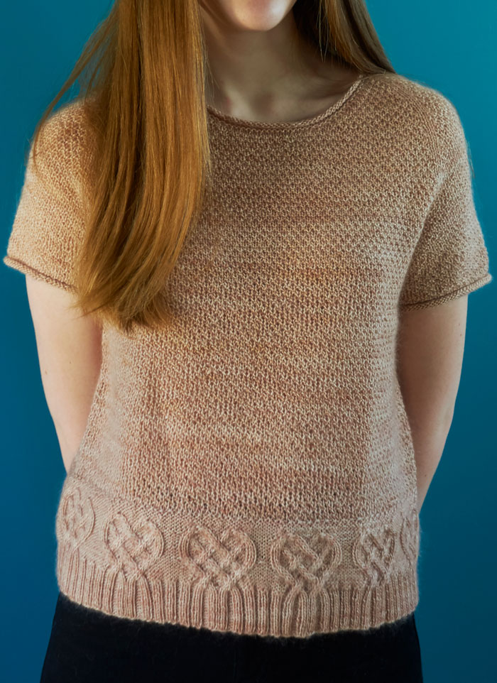 A young girl wearing a short sleeved jumper