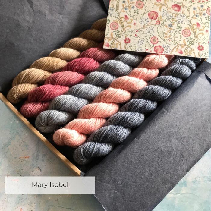 Five mini skeins of yarn in a tissue wrapped box with the inspiration card
