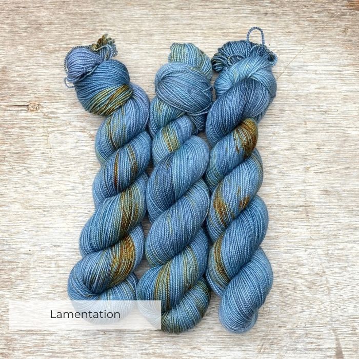 Three skeins of sock wool in cool blue splashed with gold
