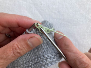 Second stitch on right hand needle is lifted over the first stitch to cast off