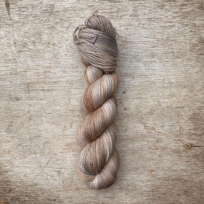 A single skein of sock wool in neutral creams and buff