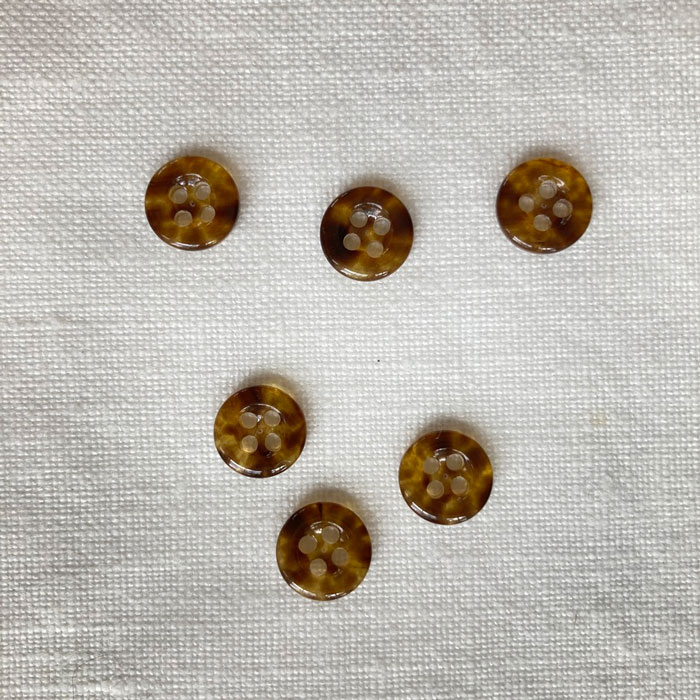 Six small round imitation tortoise shell four hole buttons