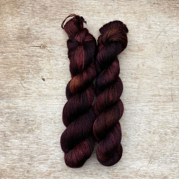 two skeins of yarn in brown, dusty pink and bronze