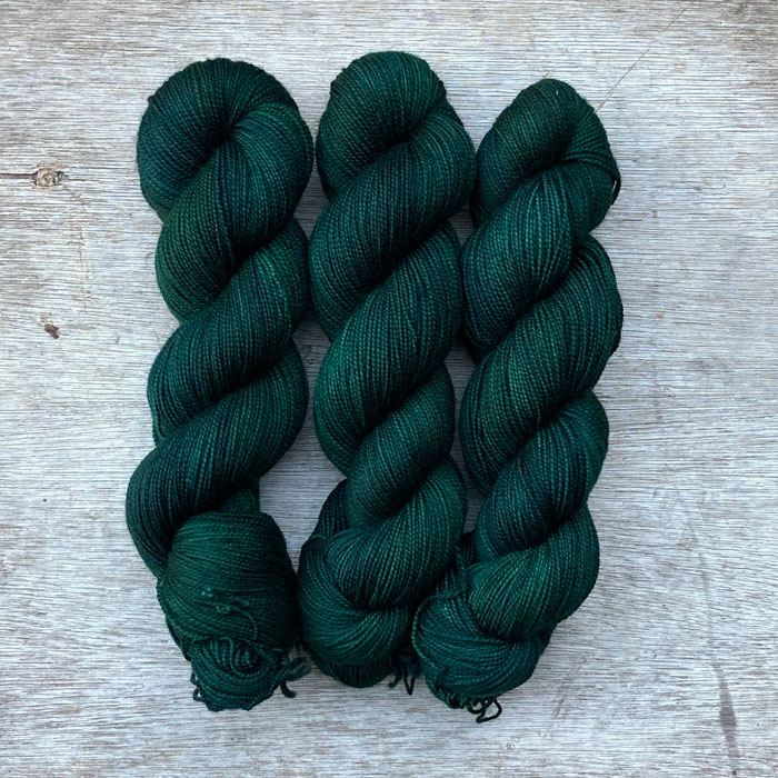 Three skeins of deep bottle green wool