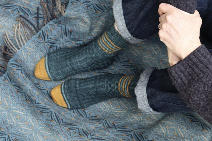 Feet in blue striped socks on a wool blanket