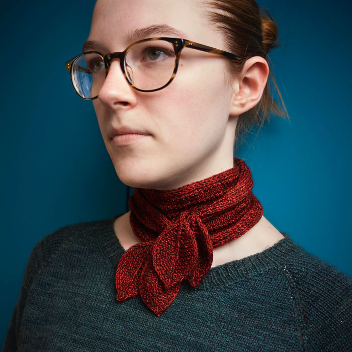 A picture of a young woman wearing glasses and a jaunty red scarf
