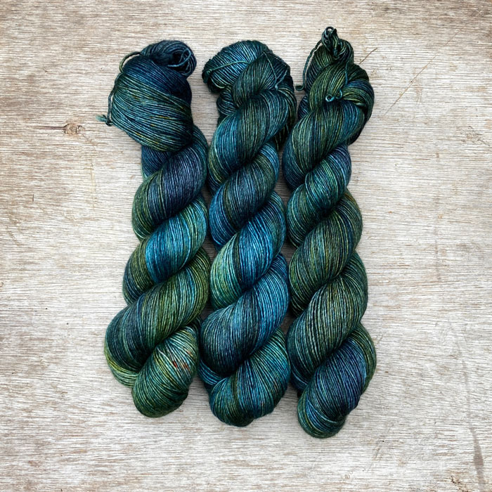 Three skeins of softly silky yarn in shades of dark blue, green and teal