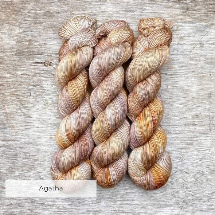 Three skeins cream, pink and gold merino and mohair sock yarn