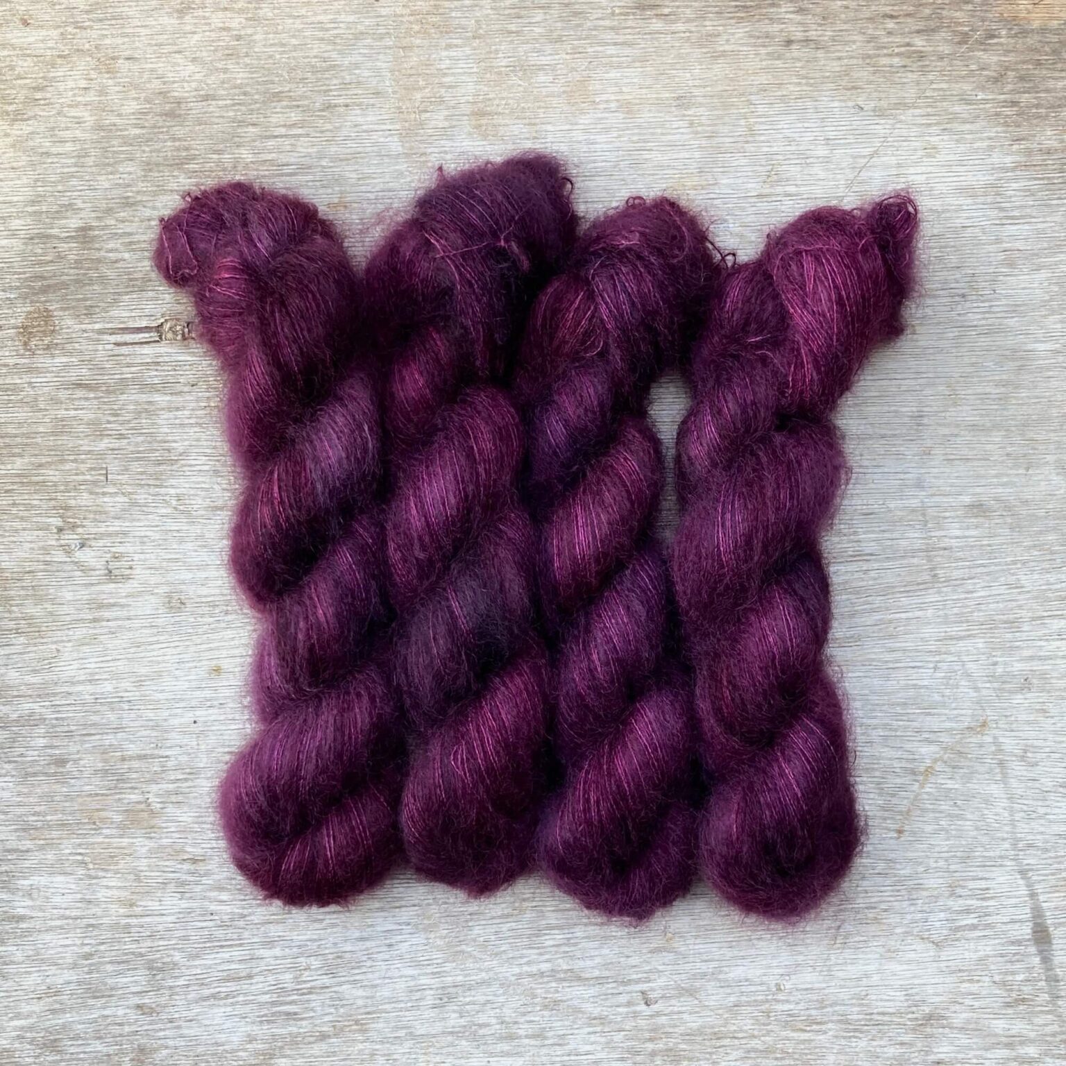 Four skeins of mohair and silk lace in a blackberry purple