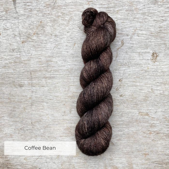 A single skein of merino & silk in a dark grey brown