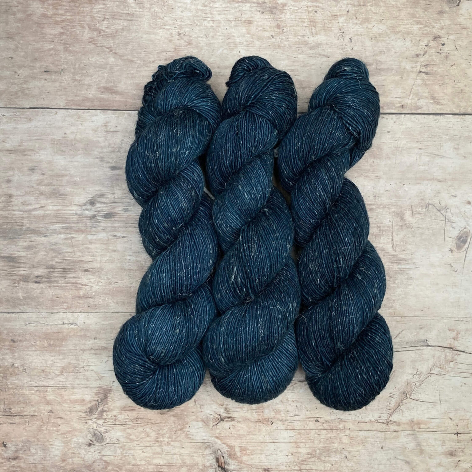 Three skeins of Flax yarn in a deep dark blue