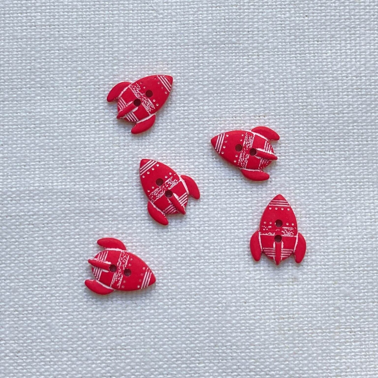 Five scarlet red rocket shaped buttons