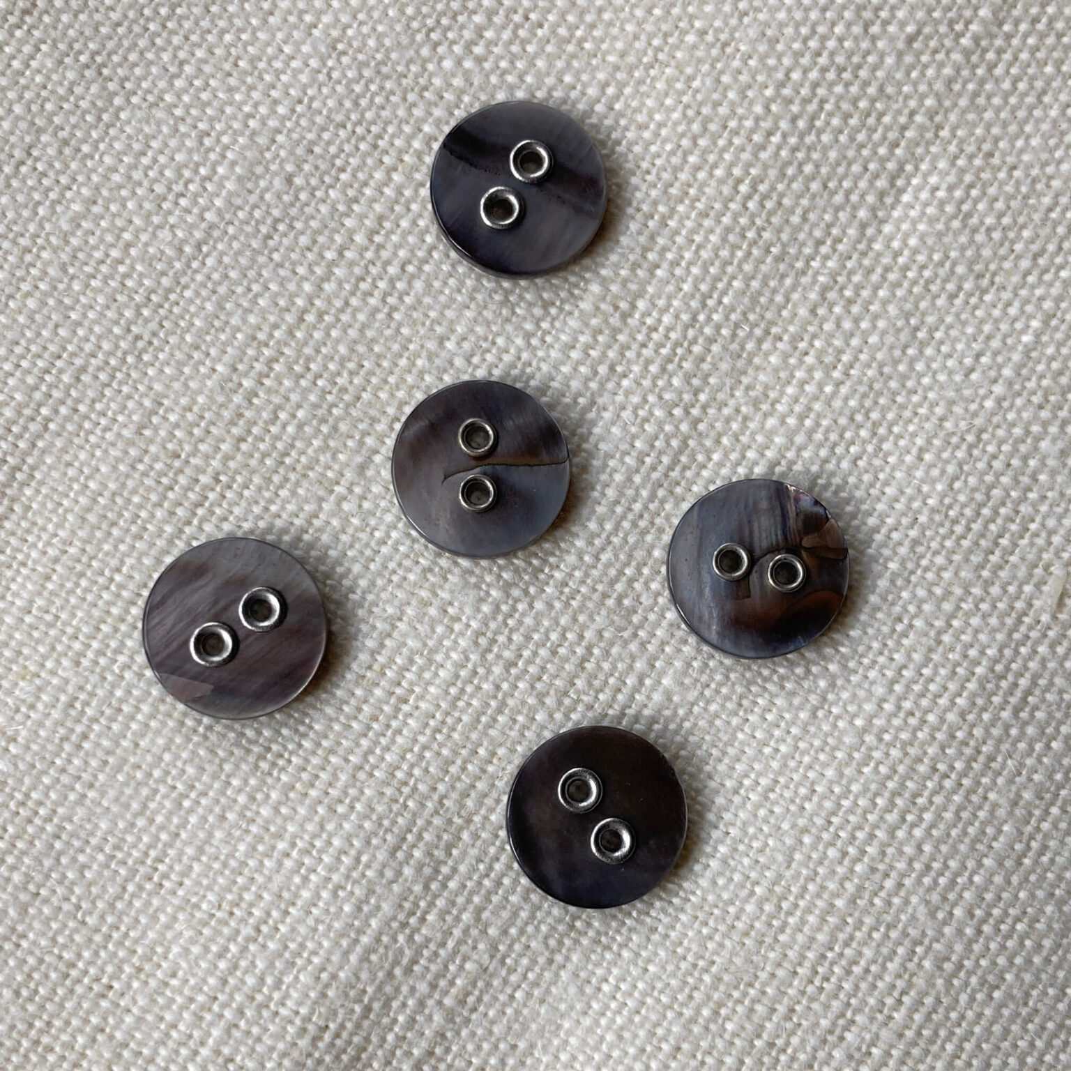 Five grey coloured shell buttons with metal holes 11mm