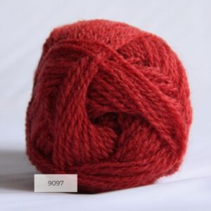 The end of a single ball of shetland wool in a bright coral colour