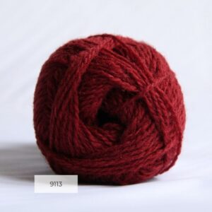 The end of a single ball of shetland wool in a deep red colour