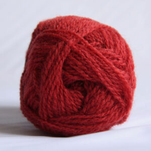 The end of a single ball of shetland wool in a bright coral colour