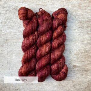 Three skeins of yarn a golden burgundy colour