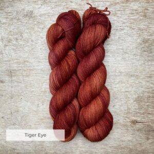 Two skeins of yarn a golden burgundy colour