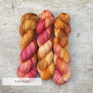 Three skeins of Classic Sock in mustard and raspberry pink