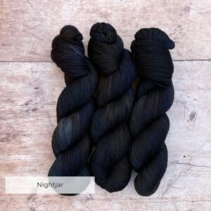 Three skeins of Classic Sock in deep greens, inky blues and rust