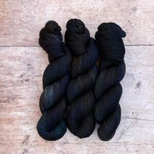 Three skeins of Classic Sock in deep greens, inky blues and rust