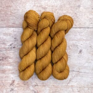 Three skeins of Classic Sock in a deep golden ochre