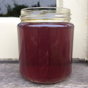 A jam jar of dark pink dye