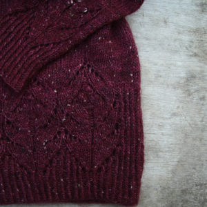 A jumper lying on a wooden background showing the pattern detail