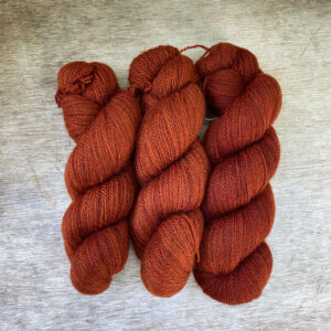 Three skeins of orange scarlet wool
