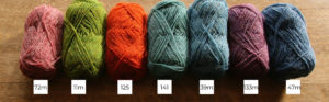 Seven balls of Shetland wool lined up in a row from light to dark