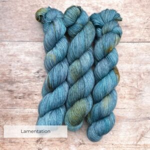 Three skeins of Merino Floof in mid denim blue with golden splashes