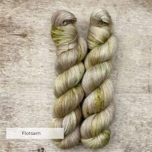 Two skeins of yarn in a neutral stone splashed with moss green