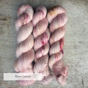 The skeins of fluffy pink yarn speckled in plums and gold
